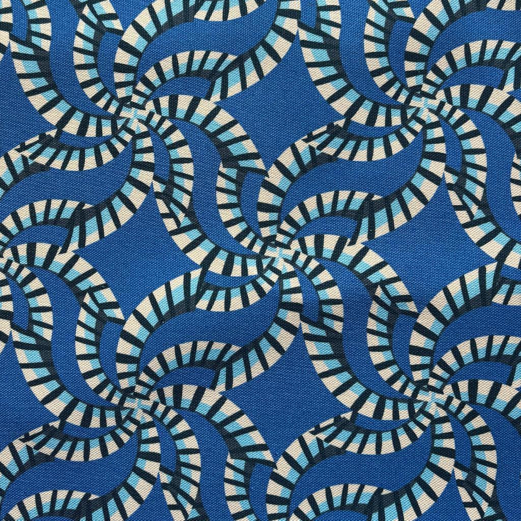 Blue and white patterned fabric with a hand touching it