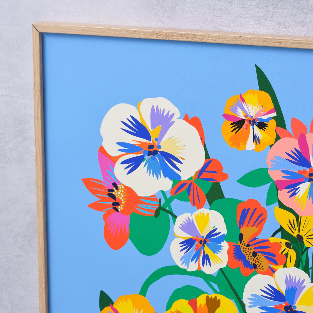 Close-up detail of the Pansy Vase fine art print by Kitty McCall showing bold white, yellow and orange pansy blooms on a cornflower blue background