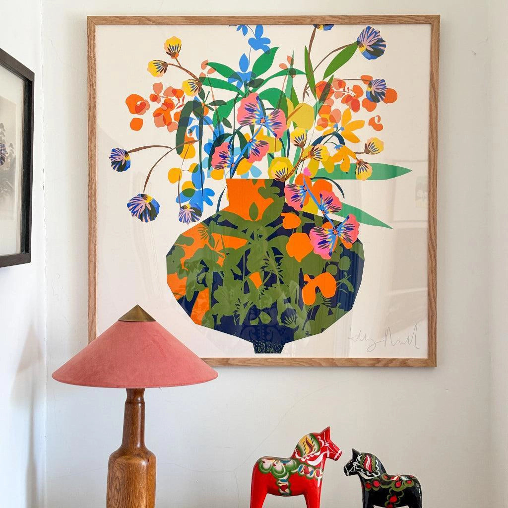 Utopia Vase fine art print by Kitty McCall in a natural oak frame, styled on a white wall above a pink lamp and a pair of red Dala horses