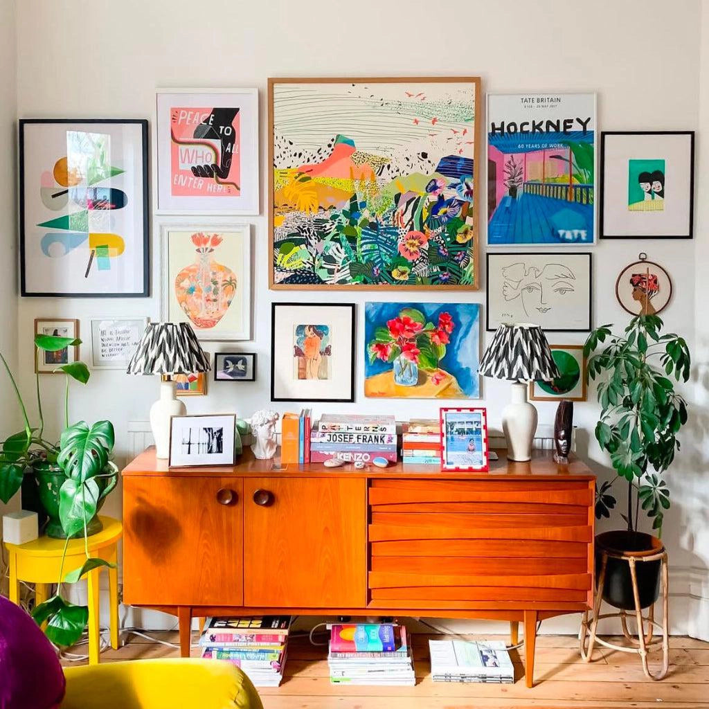 Flowers of Utopia fine art print by Kitty McCall in a natural oak frame, displayed on a colourful gallery wall above a vintage sideboard