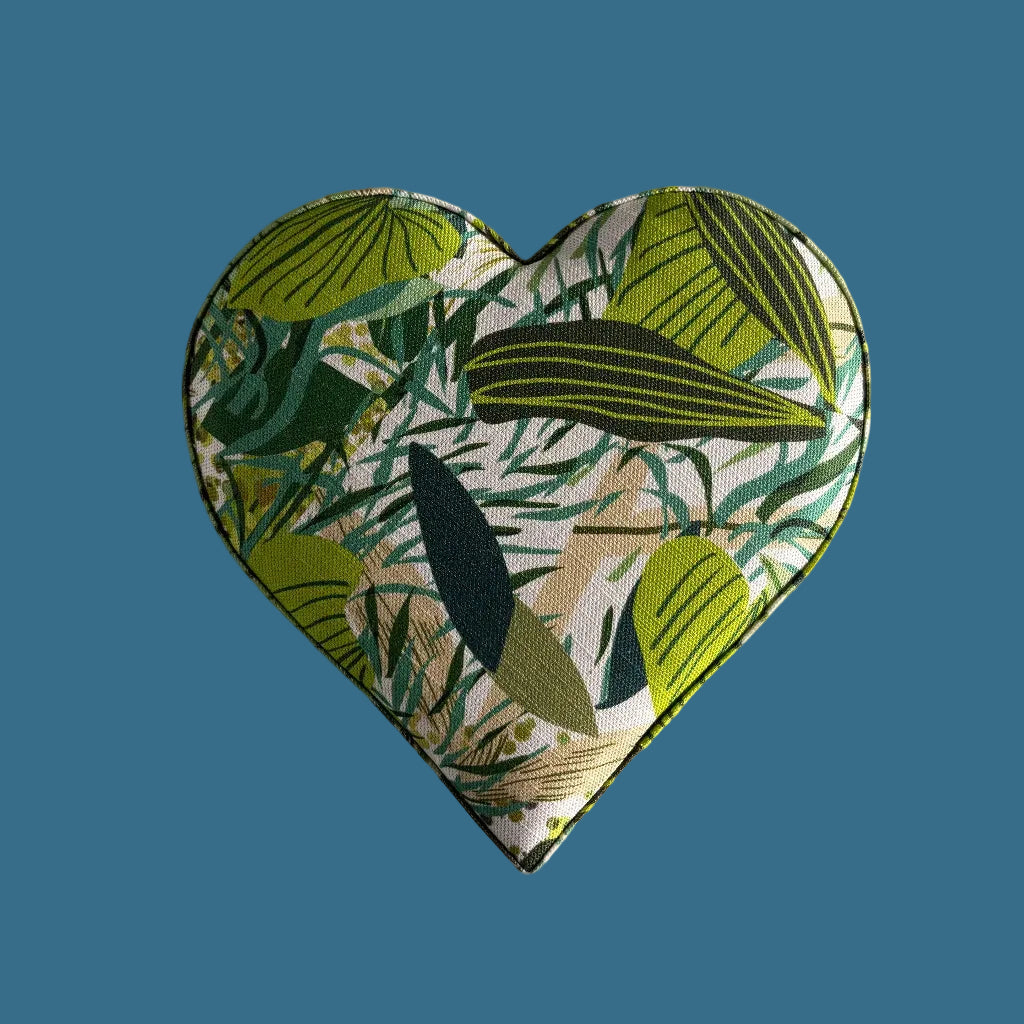 Heart-shaped fabric patch with green leaf pattern on a beige background