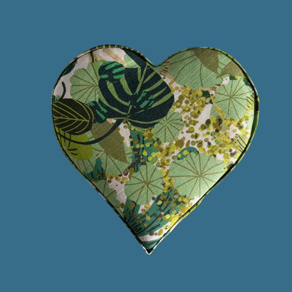 Heart-shaped fabric pouch with green floral pattern on a light gray background