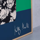 Close-up detail of the Daisy Vase fine art print by Kitty McCall showing the artist's signature on the navy base with the black and white daisy-patterned vase