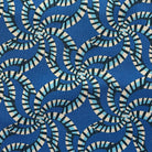 Blue and white patterned fabric with a hand touching it