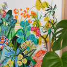 Close-up detail of the Etruscan Forest fine art print by Kitty McCall showing teal and orange wildflowers with a monstera leaf in the foreground