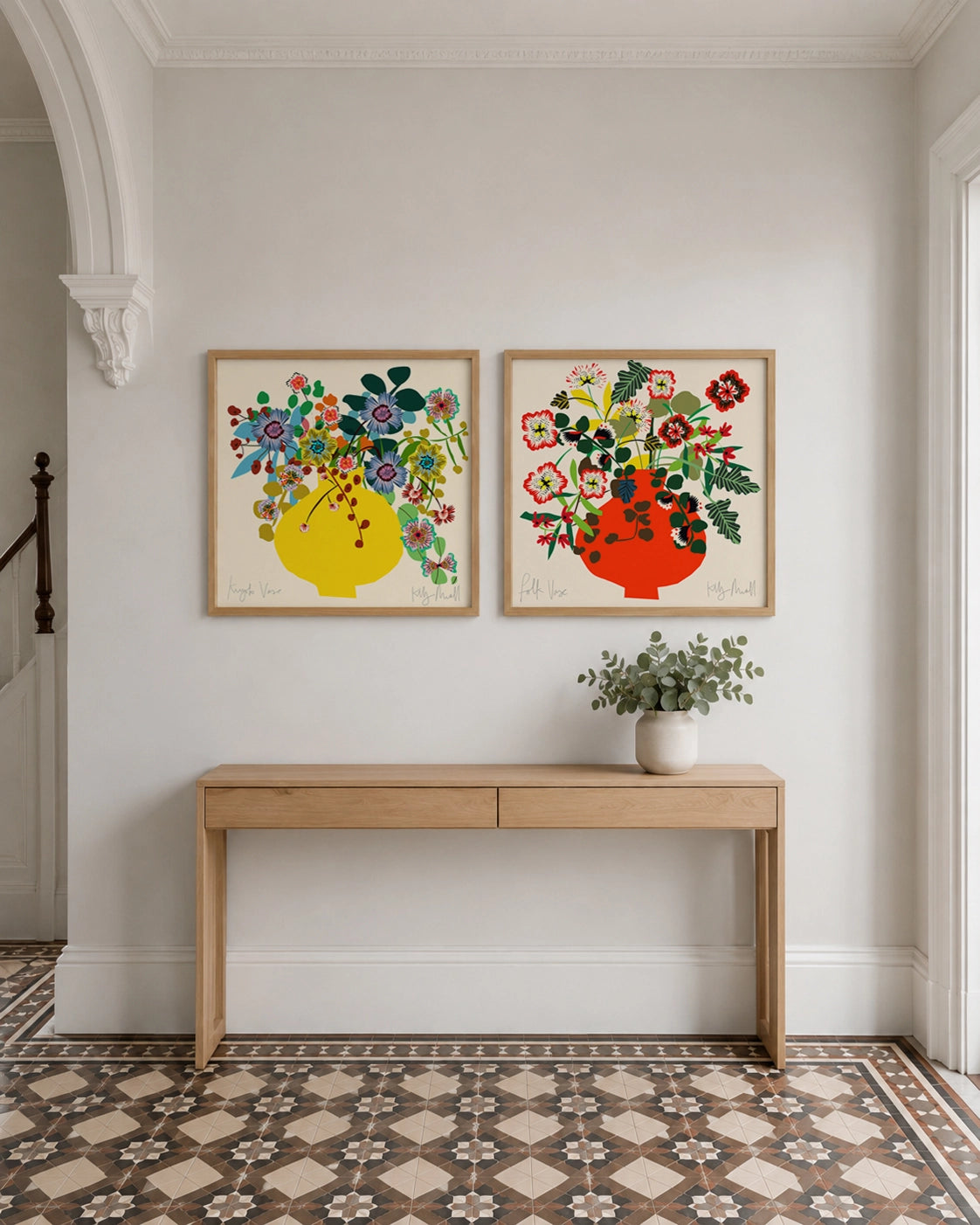 Kyoto Vase and Folk Vase fine art prints by Kitty McCall in natural oak frames above a console table in a bright hallway
