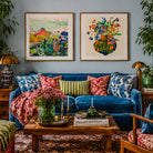 Living room with a blue sofa, colorful pillows, and two framed artworks on the wall.