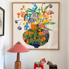 Utopia Vase fine art print by Kitty McCall in a natural oak frame, styled on a white wall above a pink lamp and a pair of red Dala horses