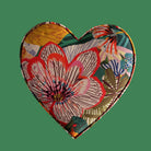 Heart-shaped fabric coaster with floral pattern on a light gray background