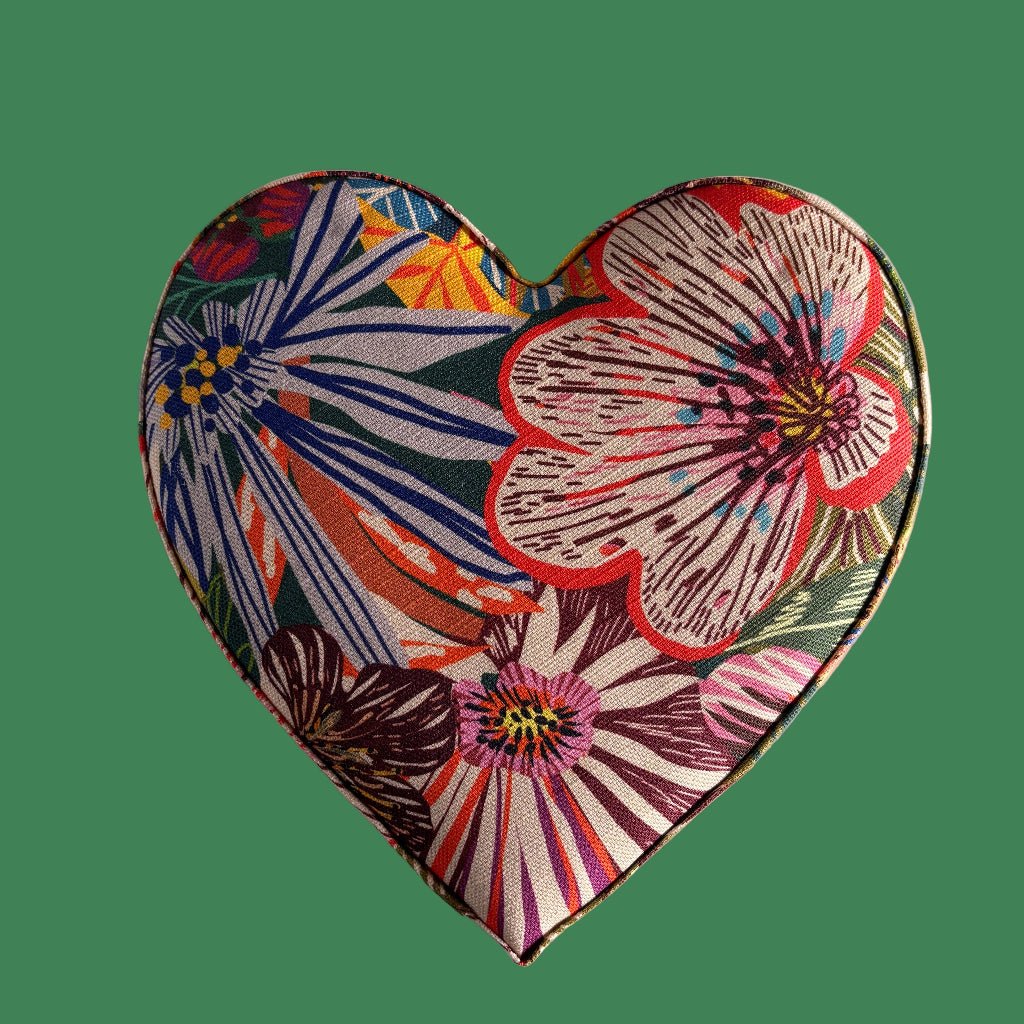 Heart-shaped decorative item with floral pattern on a green background