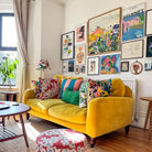 Flowers of Utopia fine art print by Kitty McCall in a natural oak frame on a gallery wall above a yellow velvet sofa
