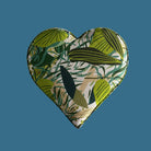 Heart-shaped fabric patch with green leaf pattern on a beige background