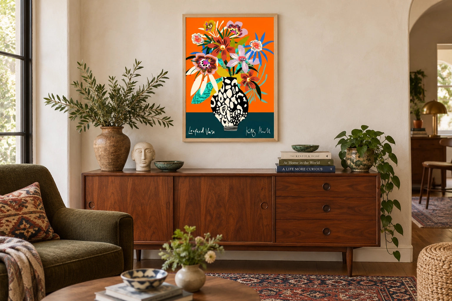 Leopard Vase fine art print by Kitty McCall in a natural oak frame, hung above a mid-century walnut sideboard in a warm living room styled with olive armchair, ceramic vessels and stacked books